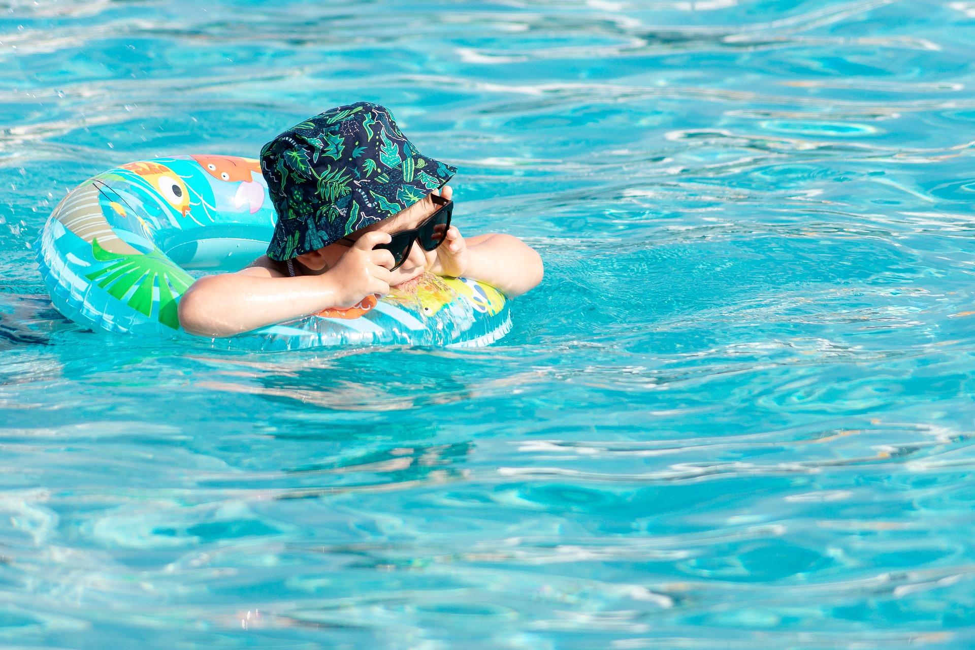 Niño pequeño con su flotador en una piscina disfrutando y pasando un buen rato mientras desconecta