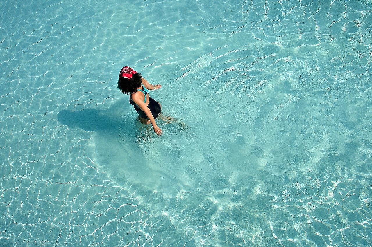 Chica tranquila y relajada caminando por una piscina