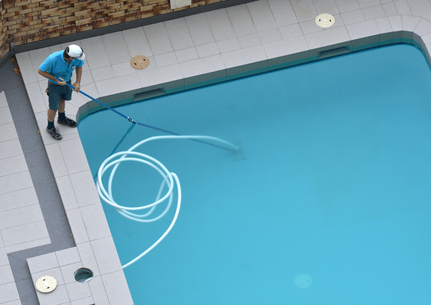 Persona limpiando piscina de poliéster
