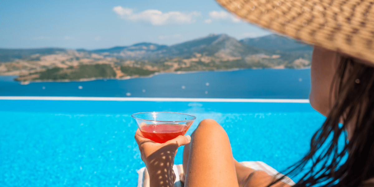 Mujer tomándose un Martini en su piscina de la Costa Brava